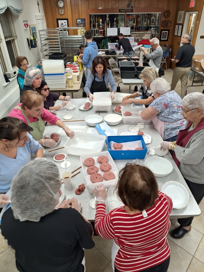 Volunteers forming losh patties together in the church hall